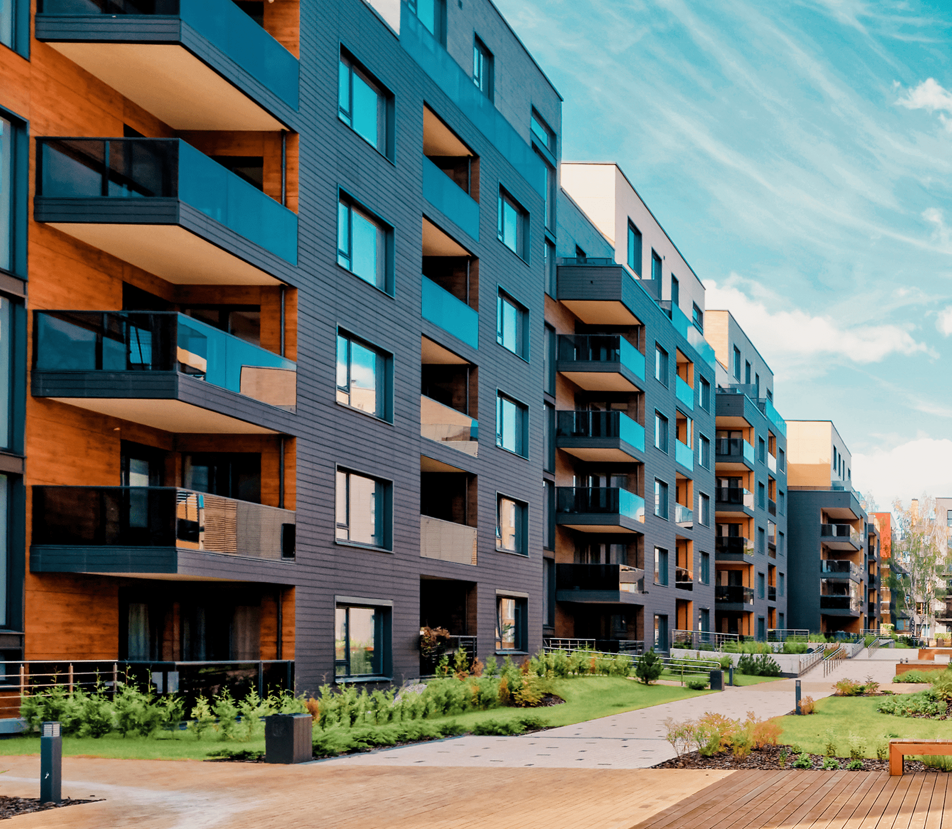 Modern apartment buildings with landscaped pathways.