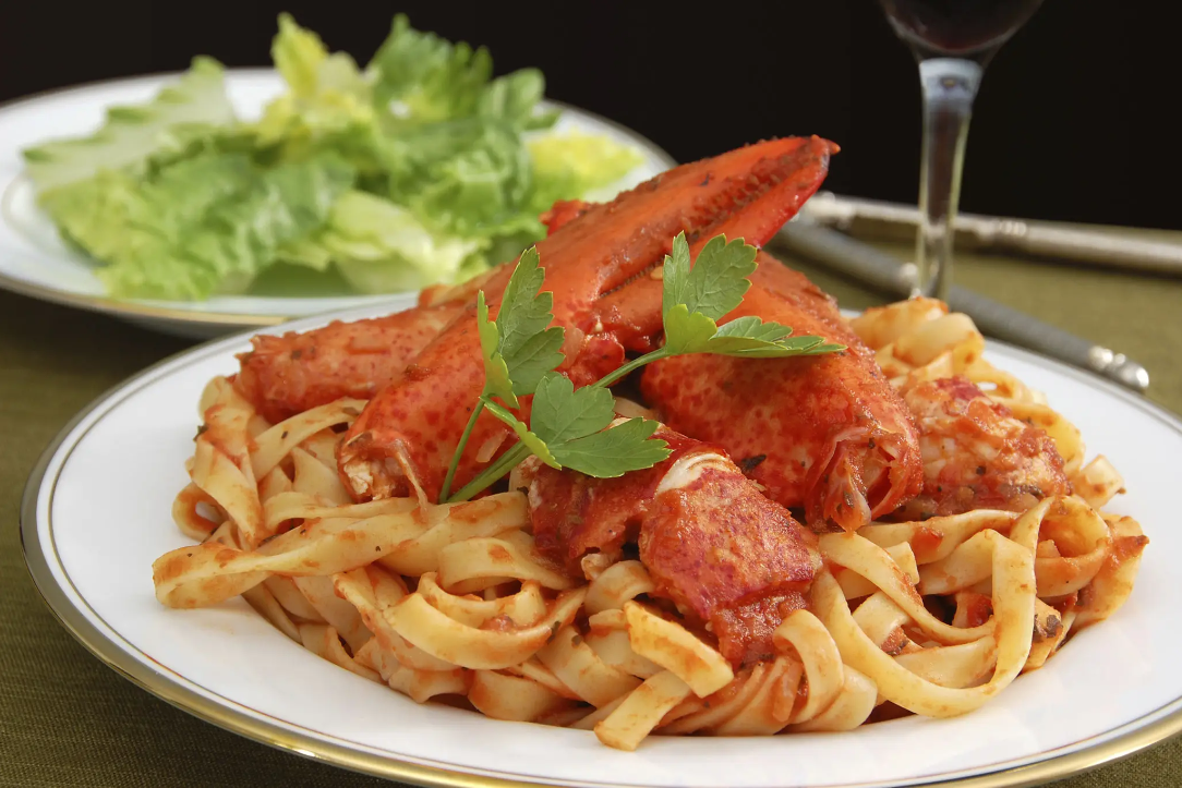 Gourmet seafood pasta, wine, and green salad