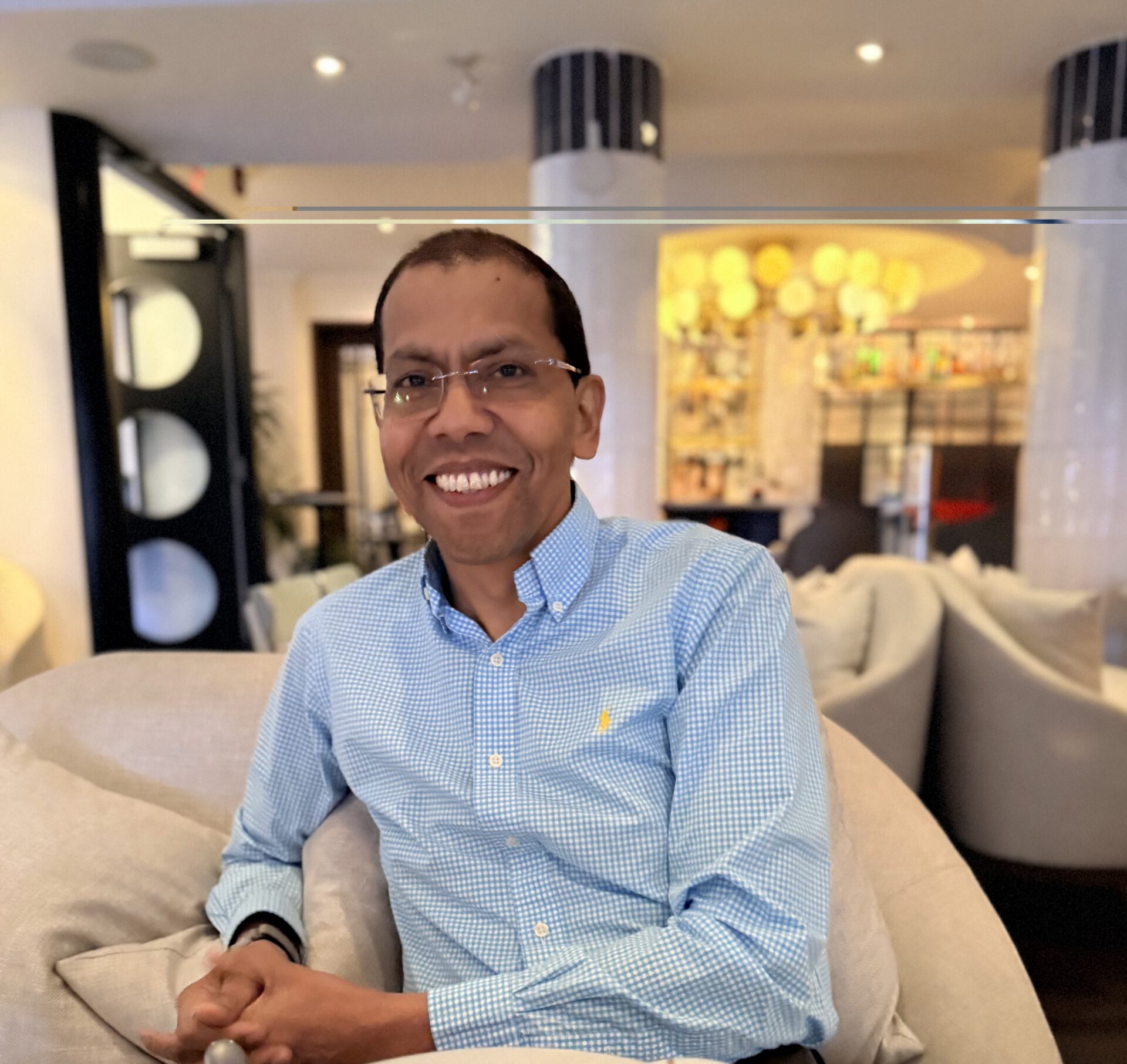 Portrait of a smiling hotel hospitality professional seated in a lounge